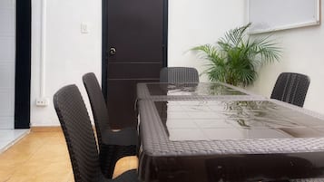 Een vergaderruimte met een tafel met glazen blad, zwarte stoelen, een deur met het nummer 3 en een potplant.