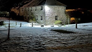 Een gebouw van steen met een schuin dak en veel ramen, gelegen op een met sneeuw bedekte ondergrond.
