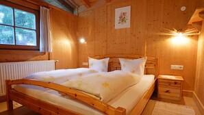 Une chambre à coucher en bois, avec un lit, des tables de chevet et une fenêtre.
