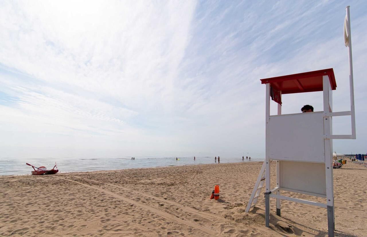 A lifeguard tower on a sandy beach with a clear sky.