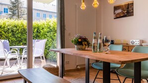 A dining area with a wooden table, chairs, and a view of greenery outside. - Baltic Sea Mermaid, Green Lagoon (Ostseebad Wustrow)