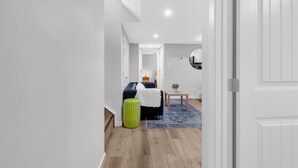 A hallway with a bed, a small table, and a mirror. - ModernSuite*NearAirport*2 Queens*ROKU (Edmonton)