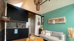 A modern living space with a kitchen, a grey sofa, a wooden coffee table, and a decorative vase. - House with mountain views

 (Checa)