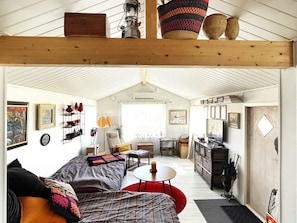 A cozy interior with a loft bed, a dining area, and a kitchen.