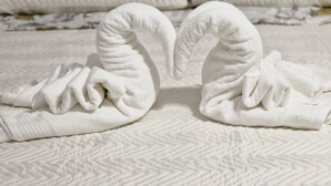 Two towels shaped like swans on a textured white bedspread. - 1 Bedroom Apartment in Bisceglie (Bisceglie)