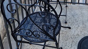 A balcony with a round metal table and two chairs, surrounded by a wrought iron railing. - 1 Bedroom Apartment in Bisceglie (Bisceglie)