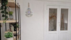 A white door with a frosted glass panel, a small potted plant, and a wooden hanger rack. - 1 Bedroom Apartment in Bisceglie (Bisceglie)