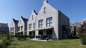A modern residential building with a symmetrical design, featuring large windows and a flat roof. - Holiday Home Traumhuus (Varel)