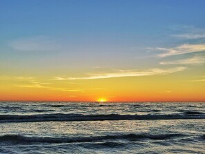 A sunset over the ocean with waves. - 4 Star Holiday Home in Blokhus (Blokhus)