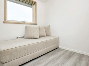 A minimalist room with a sofa, a window, and a radiator. - 4 Star Holiday Home in Blokhus (Blokhus)