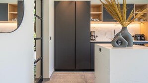 A modern kitchen with dark cabinets, a marble countertop, and a coffee machine. - Luxury Villa With Pool & Sauna Kortrijk (Kortrijk)