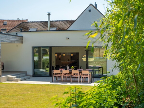 A modern house with a dining area, large windows, and a garden. - Luxury Villa With Pool & Sauna Kortrijk (Kortrijk)