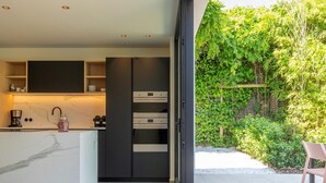 A modern kitchen with a marble countertop, built-in cabinets, and a large oven. - Luxury Villa With Pool & Sauna Kortrijk (Kortrijk)