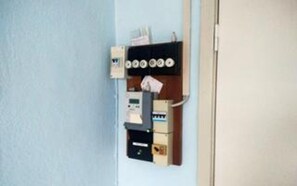 A wall-mounted electrical panel with switches and a thermostat.