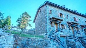 A stone building with a wooden staircase and a metal railing. - House 4 rooms 10 Pax, Fireplace, Garden & BBQ on the Slopes (La Molina)