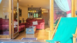 A cozy living room with red sofas, a coffee table, and a teal chair. - House 4 rooms 10 Pax, Fireplace, Garden & BBQ on the Slopes (La Molina)