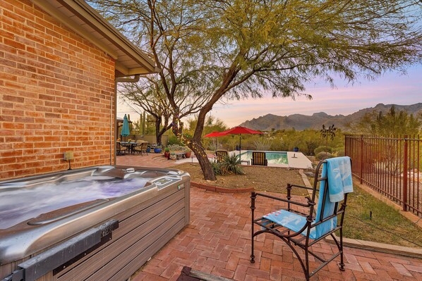 A patio with a hot tub, a covered seating area, and a view of mountains. - Private Foothills Villa + Panoramic Views + Heated Pool/Spa (Tucson)