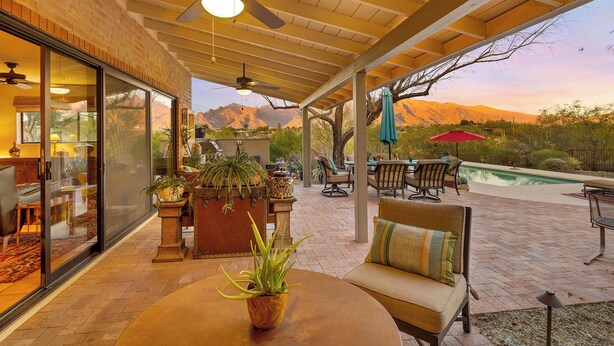 A covered patio with a pool, outdoor furniture, and a view of mountains. - Private Foothills Villa + Panoramic Views + Heated Pool/Spa (Tucson)
