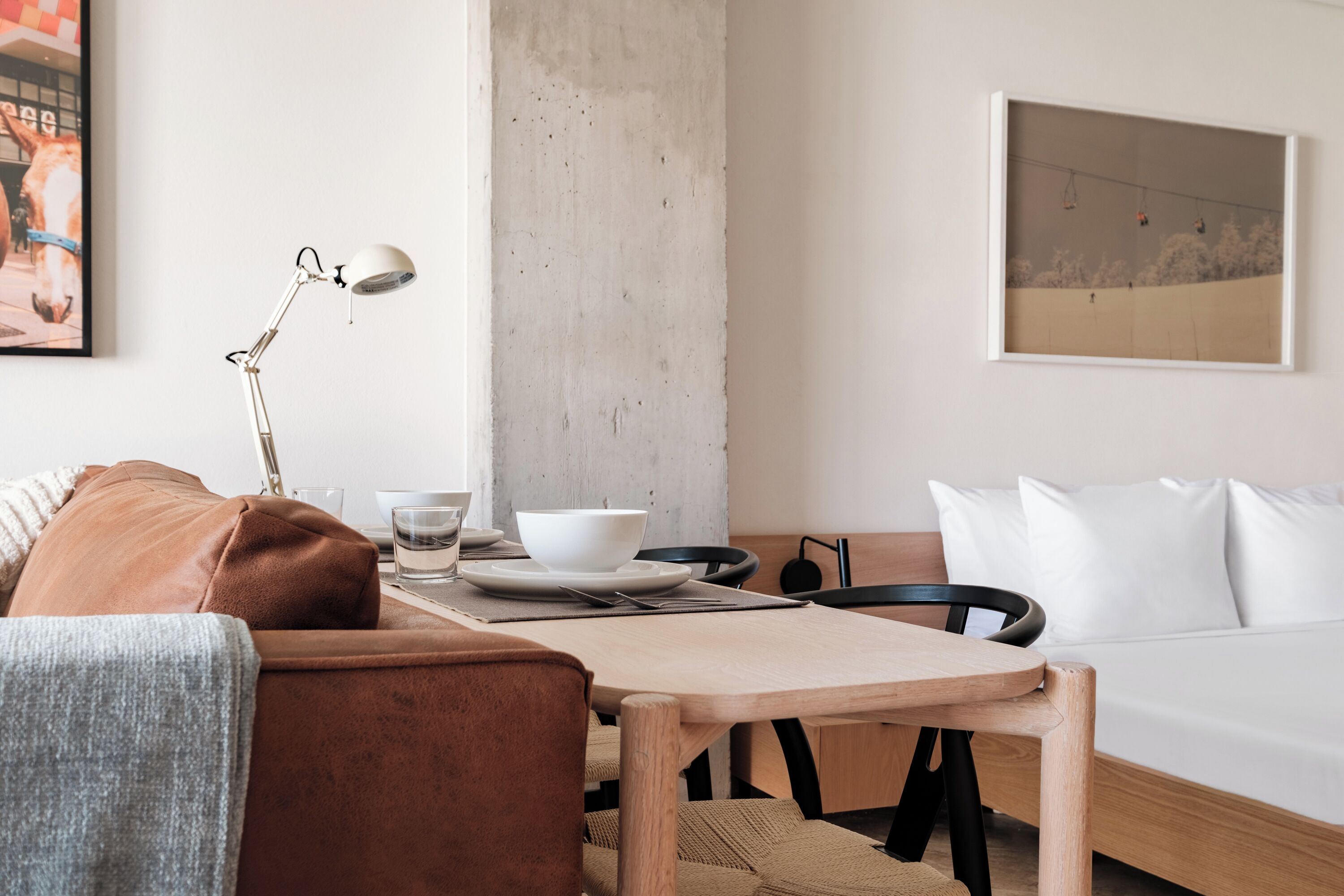 Una habitación moderna con una mesa de madera, un sofá y una cama.