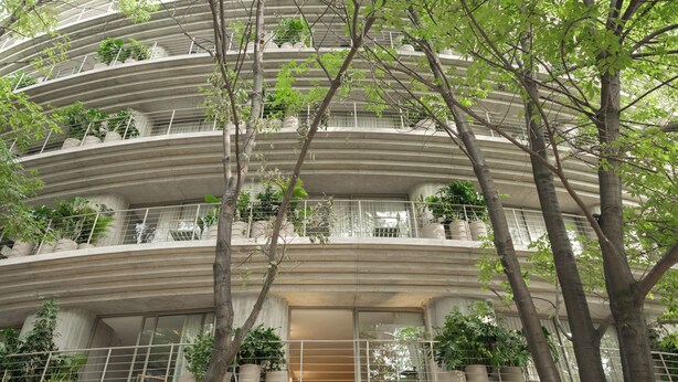 Un edificio de varios pisos con balcones, cada uno decorado con macetas de plantas.