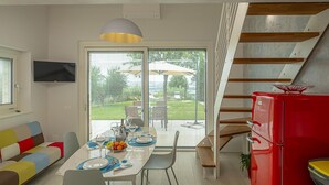 Eine moderne Küche mit Essbereich, einem roten Kühlschrank und einer Treppe zu einer oberen Ebene.