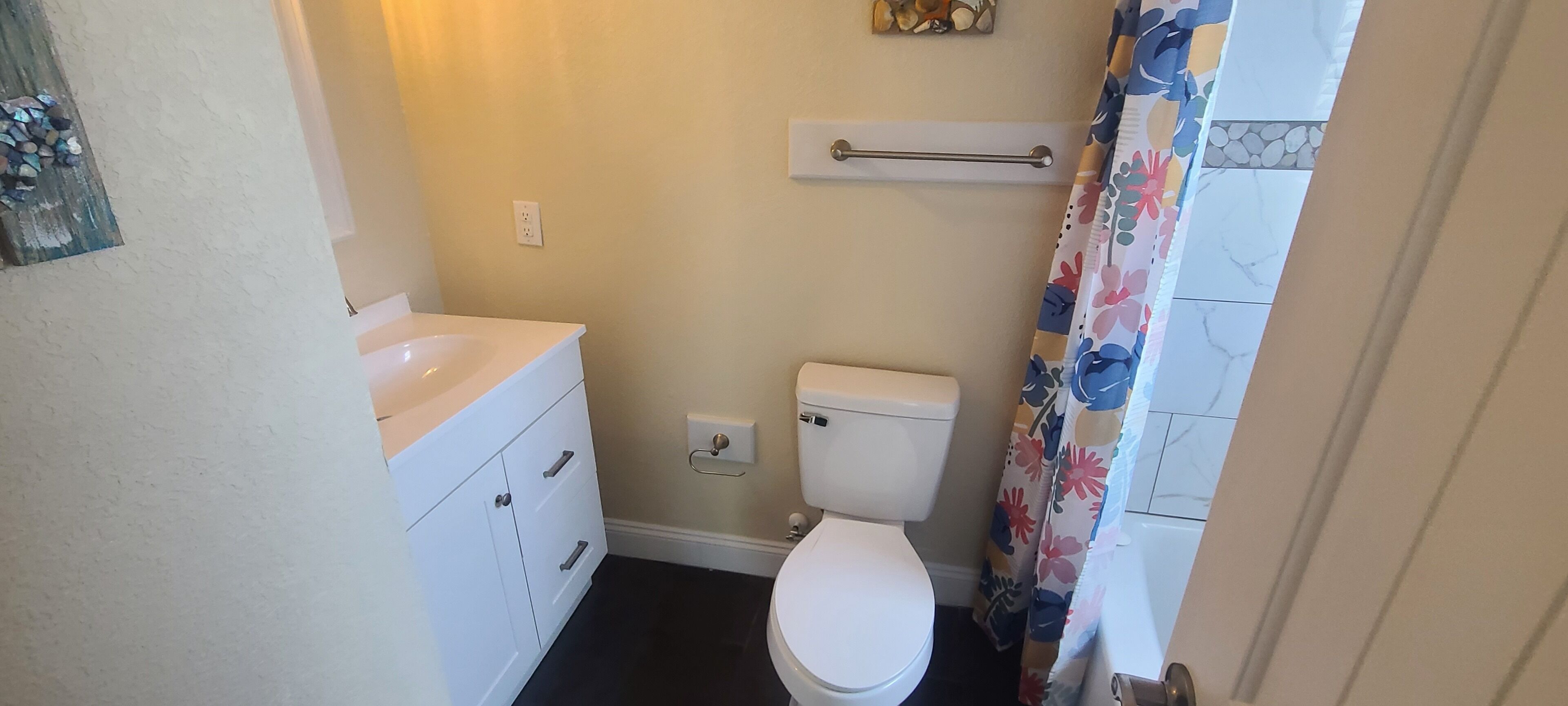 Un baño pequeño con inodoro, lavamanos y cortina de ducha.