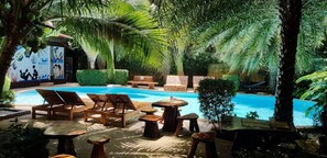 A pool area with lounge chairs, wooden tables, and a hammock. - NBC  Nai Harn Beach Condo ISI (Rawai)