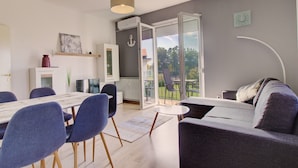 En moderne stue med spiseplads, en sofa og en balkon med udsigt.