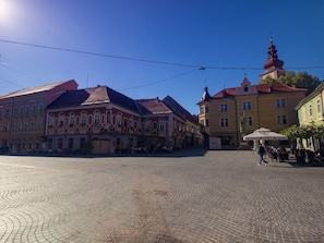 A cobblestone square with historic buildings, a church tower, and outdoor seating areas. - Lovely Apartment in Ptuj With Golf Course Nearby (Ptuj)