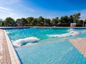 A swimming pool with clear blue water, surrounded by a tiled deck and lounge chairs. - Lovely Apartment in Ptuj With Golf Course Nearby (Ptuj)
