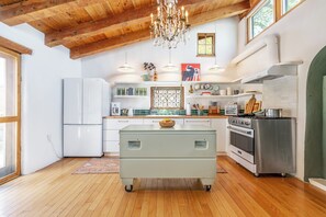 A kitchen with wooden beams, a chandelier, a refrigerator, a stove, and a sink. - Stunning Artful Adobe - Super Walkable Location (Santa Fe)