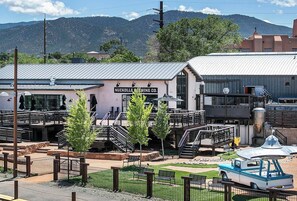 A building with a sign reading "NUCKOLLS BREWING CO." in front of a mountainous backdrop. - Stunning Artful Adobe - Super Walkable Location (Santa Fe)
