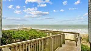 A wooden deck with a view of the ocean.