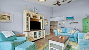 A living room with a television, two sofas, a coffee table, and a cabinet.