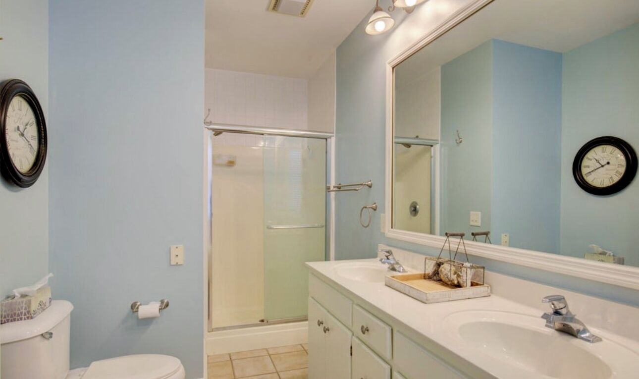 Une salle de bain avec douche, toilettes et lavabo.