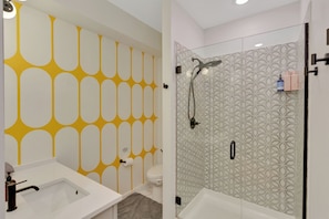 Un baño moderno con ducha, inodoro y lavabo.