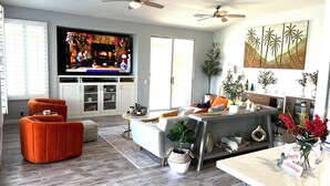 Een moderne woonkamer met een open haard, televisie en zithoek.