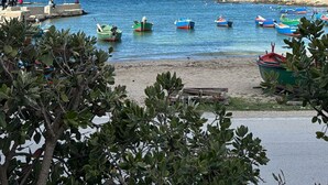 Une plage avec des bateaux, une jetée et des gens.