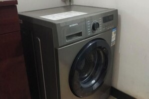 Una lavadora de carga frontal con un panel de control y una etiqueta en la parte superior.