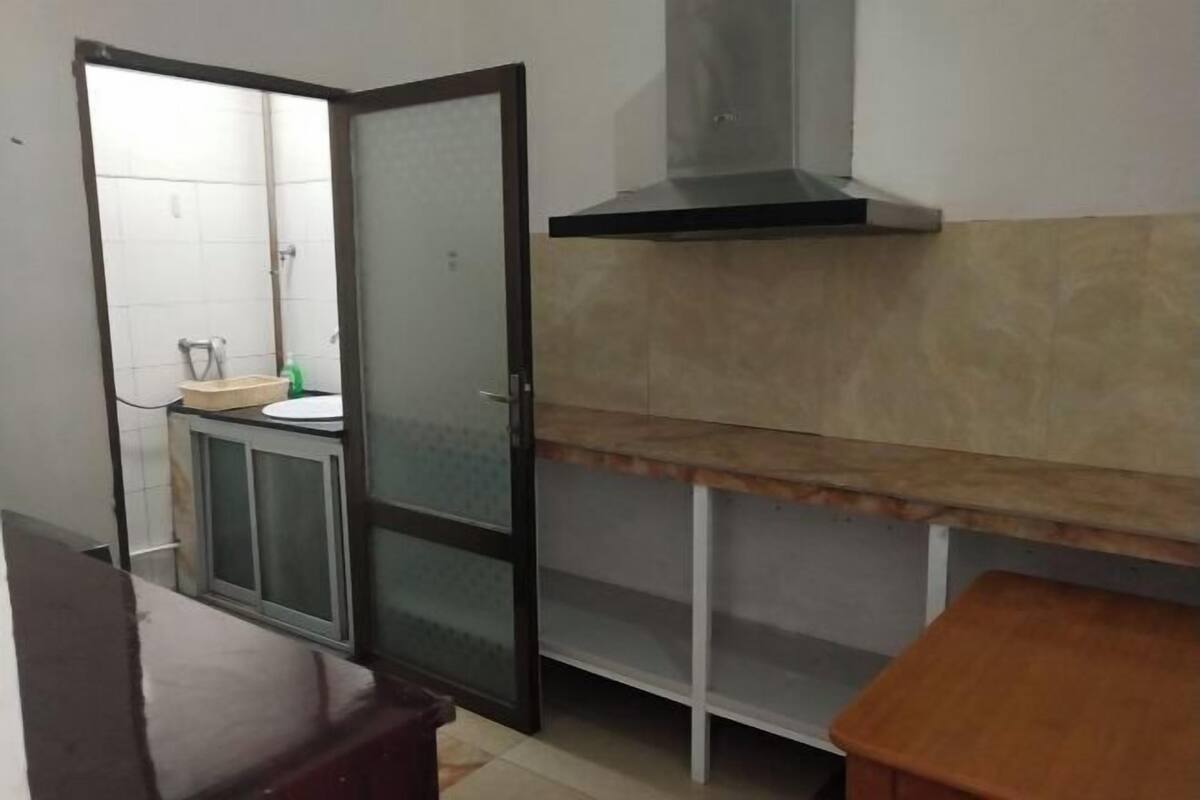 A small kitchen with a sink, a stove, and a cabinet.