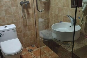 Un baño con inodoro, ducha y lavamanos.