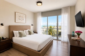 A hotel room with a bed, a desk, a TV, a window with a view, and a balcony. - Global Rent Apart (Hollywood)