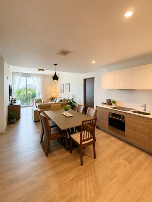 Uma cozinha moderna com área de refeições, piso de madeira e vista pela janela.
