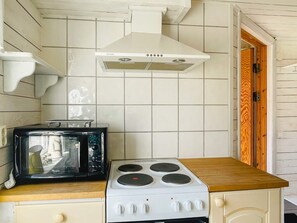 A kitchen with a white stove, a microwave, and a white tiled backsplash. - 5 Person Holiday Home in Bredared (Bredared)