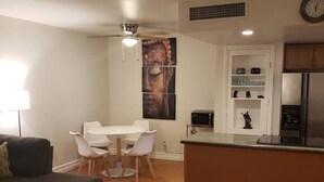 A compact living space with a dining area, kitchenette, and a sofa.