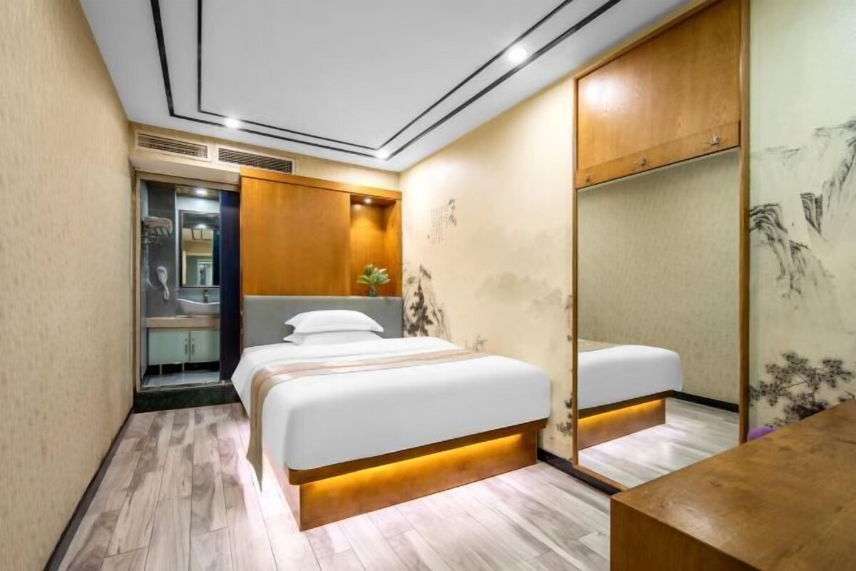A modern bedroom with a bed, wooden wardrobe, and a mirror.