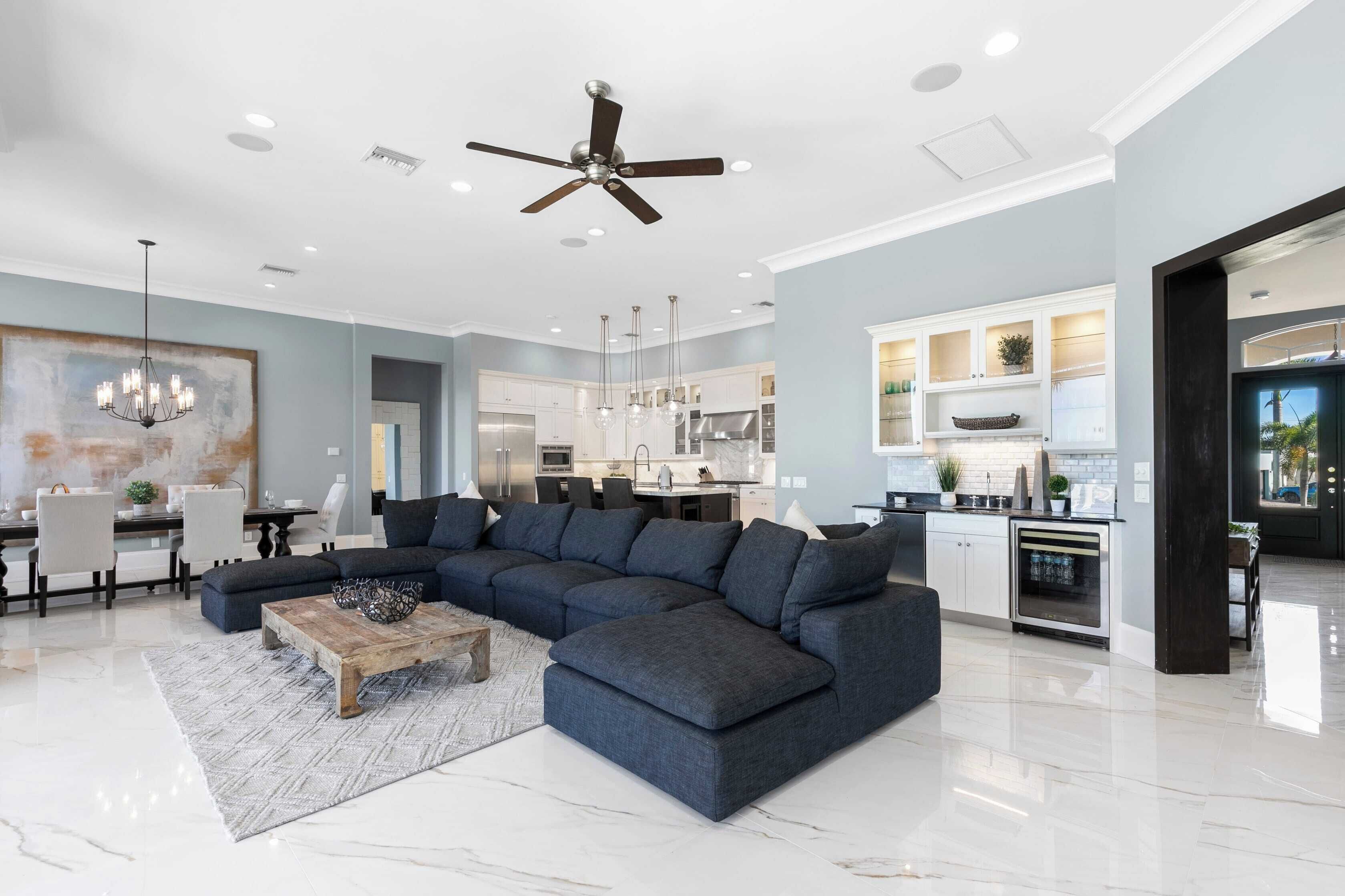 A modern living room with a sectional sofa, a wooden coffee table, and a chandelier.