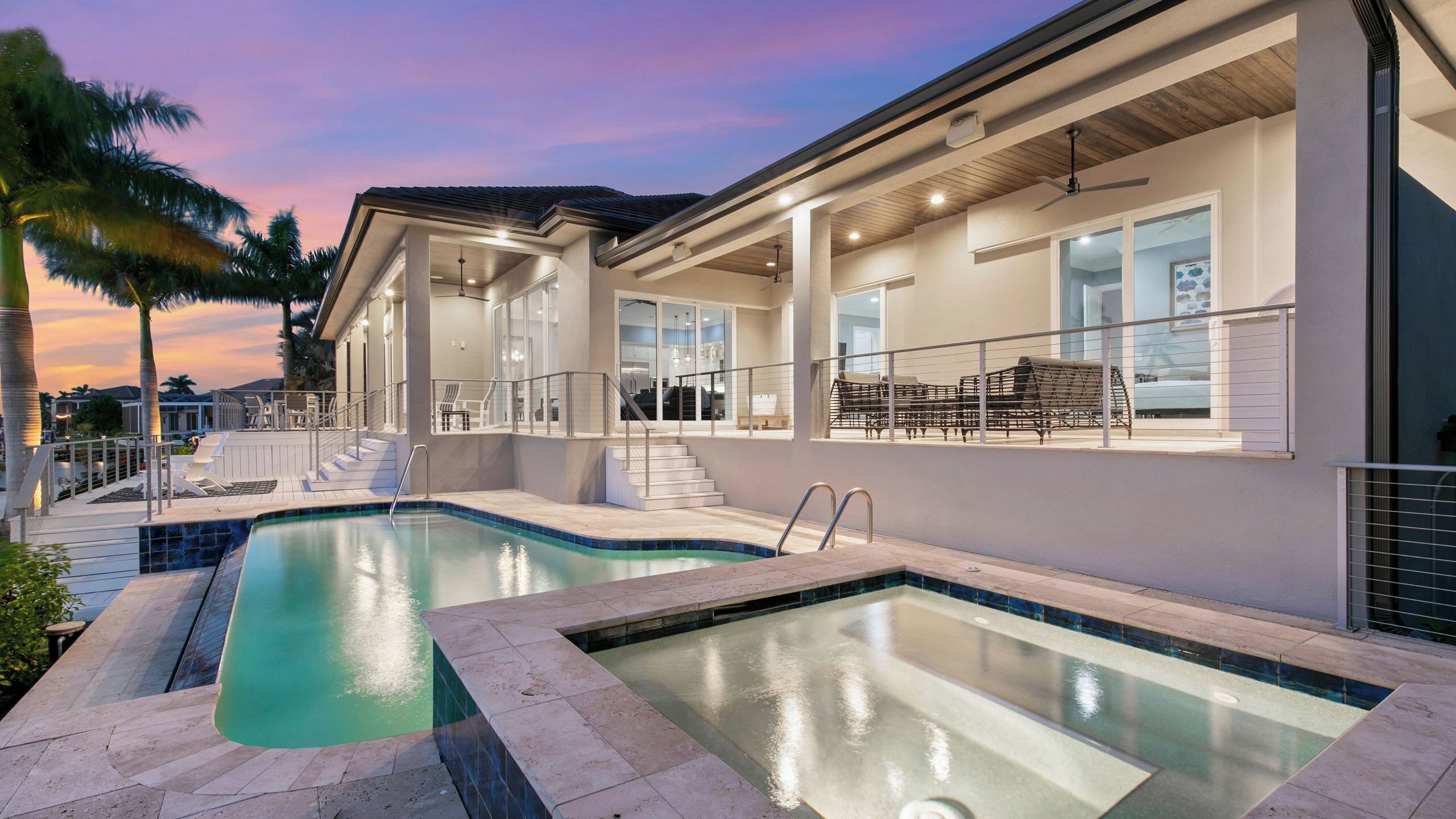 Ein modernes Haus mit Swimmingpool, Außenbereich und einer überdachten Terrasse.