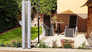 An outdoor patio with a table and chairs, a large umbrella, and a metal structure. - Holiday Apartment Mozartmansarde (Waren (Müritz))