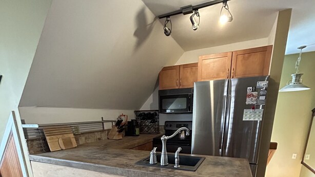A kitchen with a wooden island, stainless steel appliances, and a trash bin. - Great Asheville Location (Asheville)